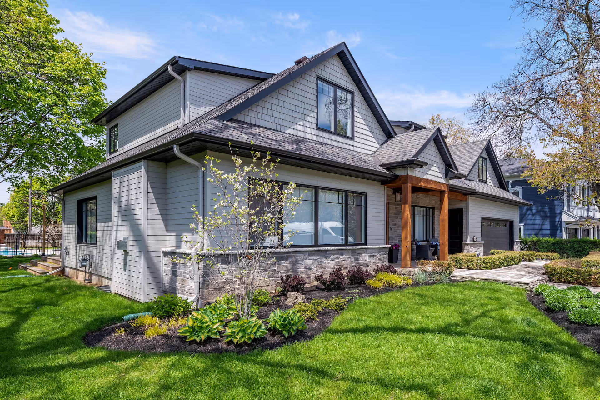 Exterior of the Burlington home after its full transformation, with shingle siding, gables and timber accents