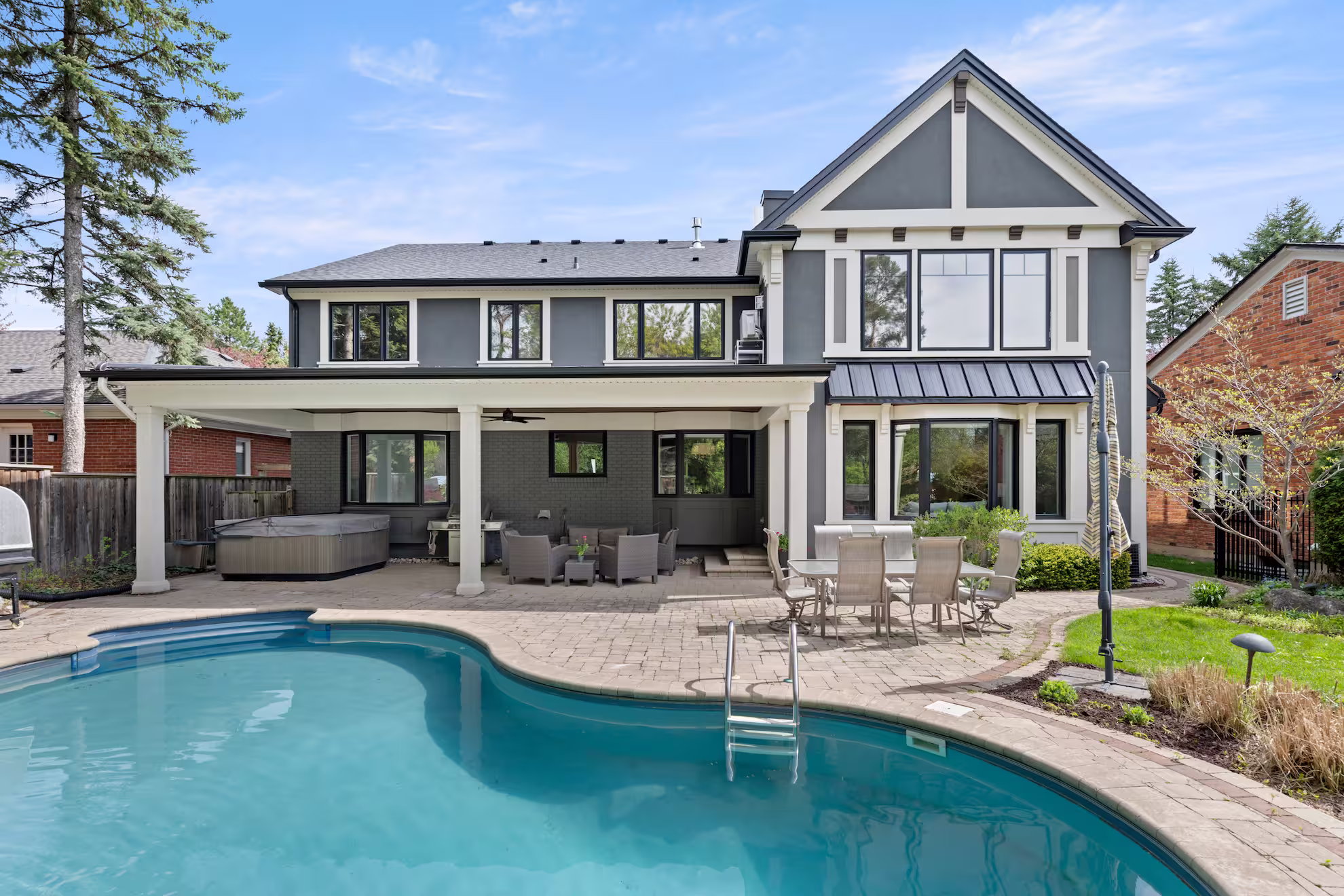 Rear of the Waterdown home after the second-storey addition, with the new covered overhang and in-ground pool