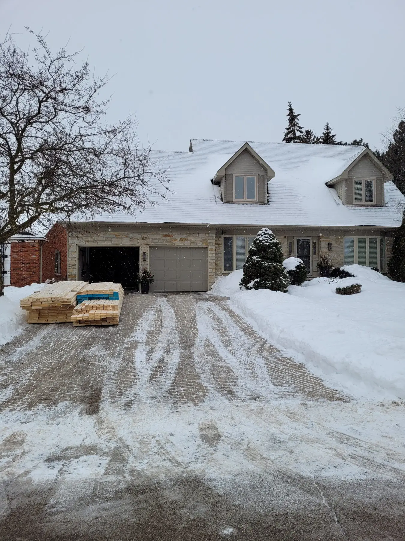 The Waterdown home before its second-storey addition, with materials stacked in the snowy driveway