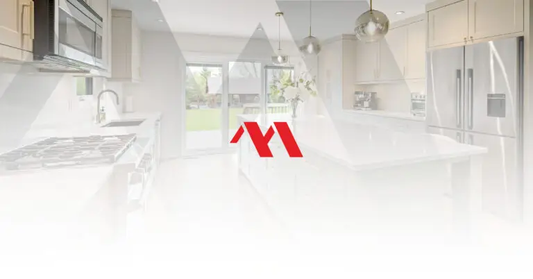 Renovated white kitchen with a quartz island, pendant lights and stainless appliances, with the Marcon Construction mark overlaid