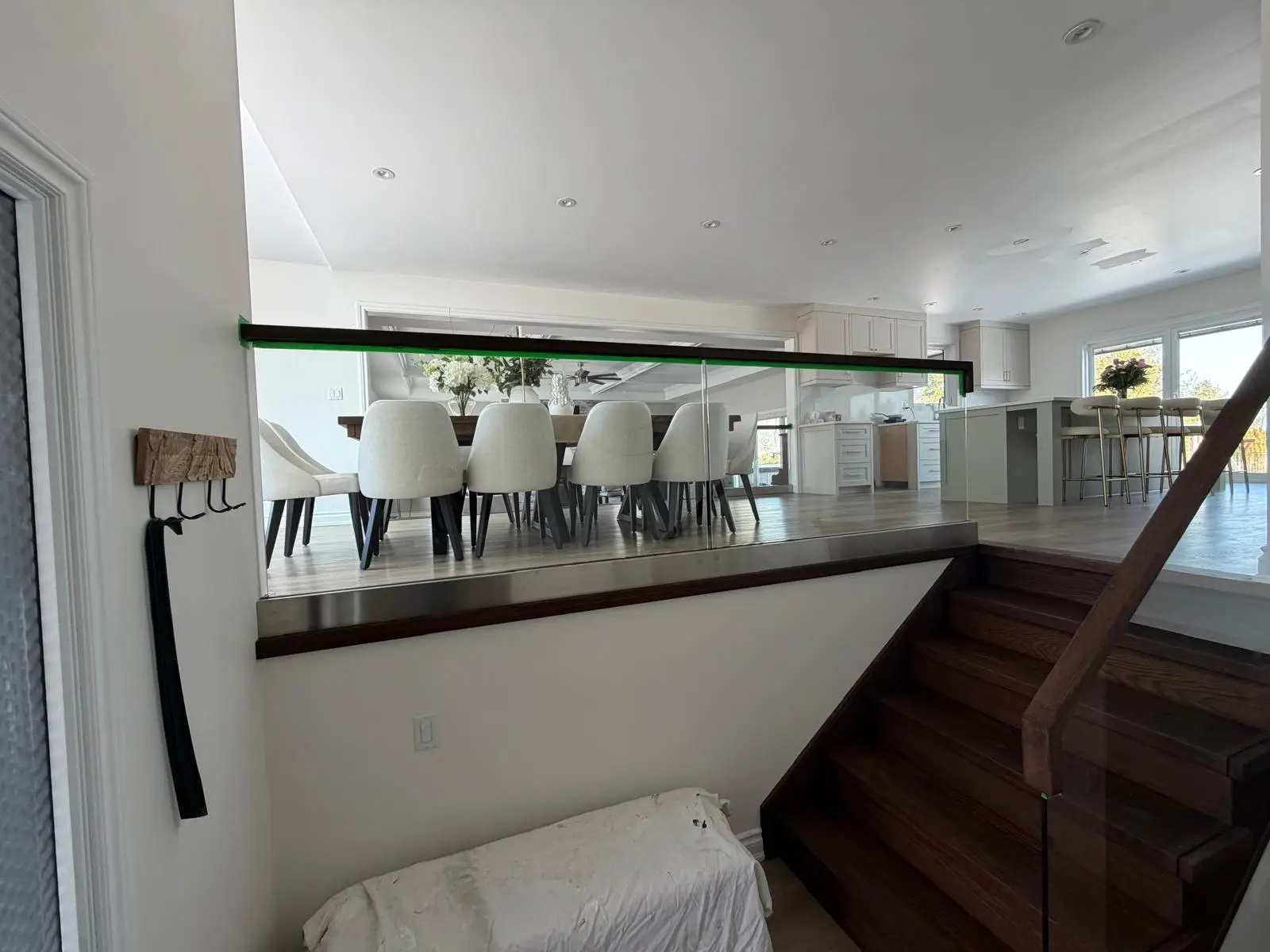 Grimsby main floor during renovation, with the new glass stair railing installed and the dining area taking shape