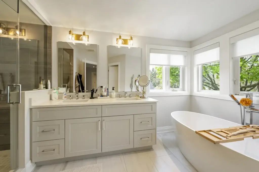 Bathroom with a double vanity, sconce lighting, glass shower and freestanding tub