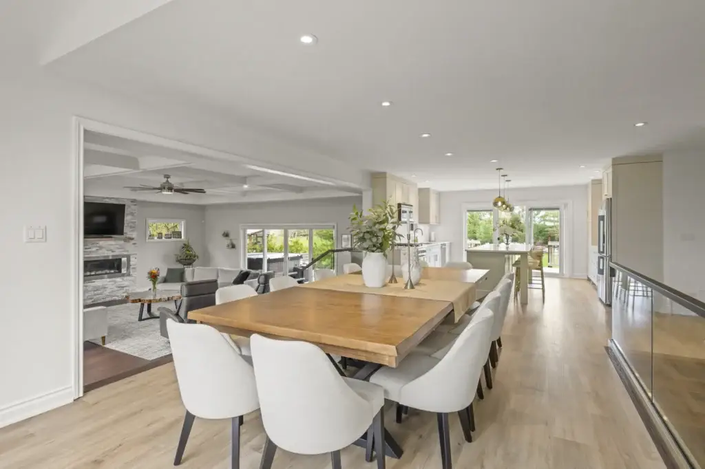 Open living and dining space with a fireplace, wood dining table and large windows